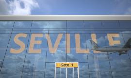 Frontal del Edificio del Aeropuerto de Sevilla con unas cristaleras que contiene unas letras amarillas que forman la palabra Sevilla